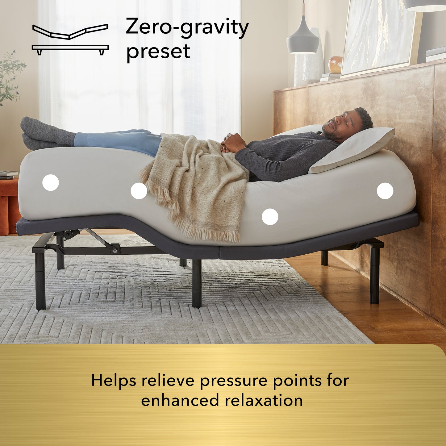 Man lying on a adjustable bed with 'Zero-gravity preset' feature in a bedroom setting.